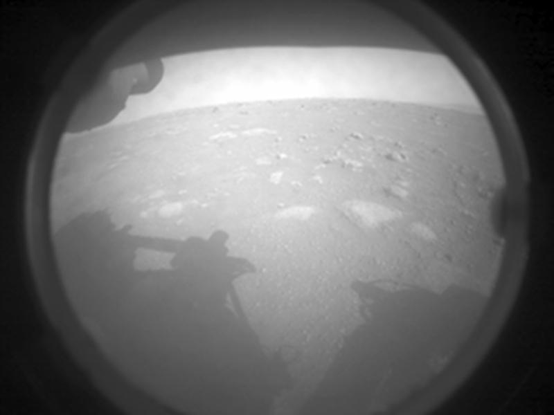 صورة بالأبيض والأسود ذات إطار دائريّ يظهر فيها سطح كوكب المريخ وفيه الكثير من الحفر مختلفة الحجم، يظهر ظلّ العربة الجوالة أسفل الصورة على السطح، كما يظهر الأفق في البعيد ومن فوقه نطاق ذو لون أفتح.